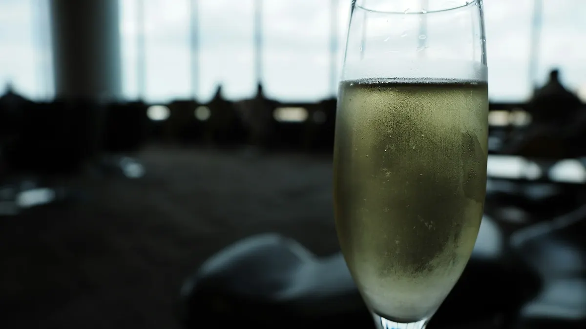 A glass of champagne on a table in a softly lit lounge