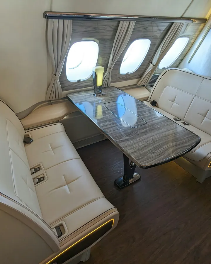 Club seats around a polished table in a private aircraft cabin
